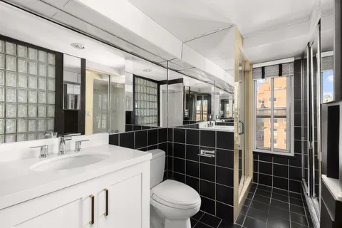 a bathroom with a sink toilet vanity and shower