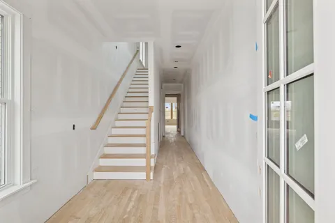 a view of a hallway with wooden floor and entryway