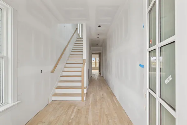 a view of a hallway with wooden floor and entryway