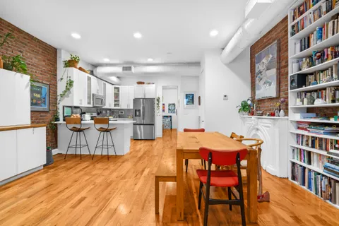 a view of a dining room with furniture and a book shelf