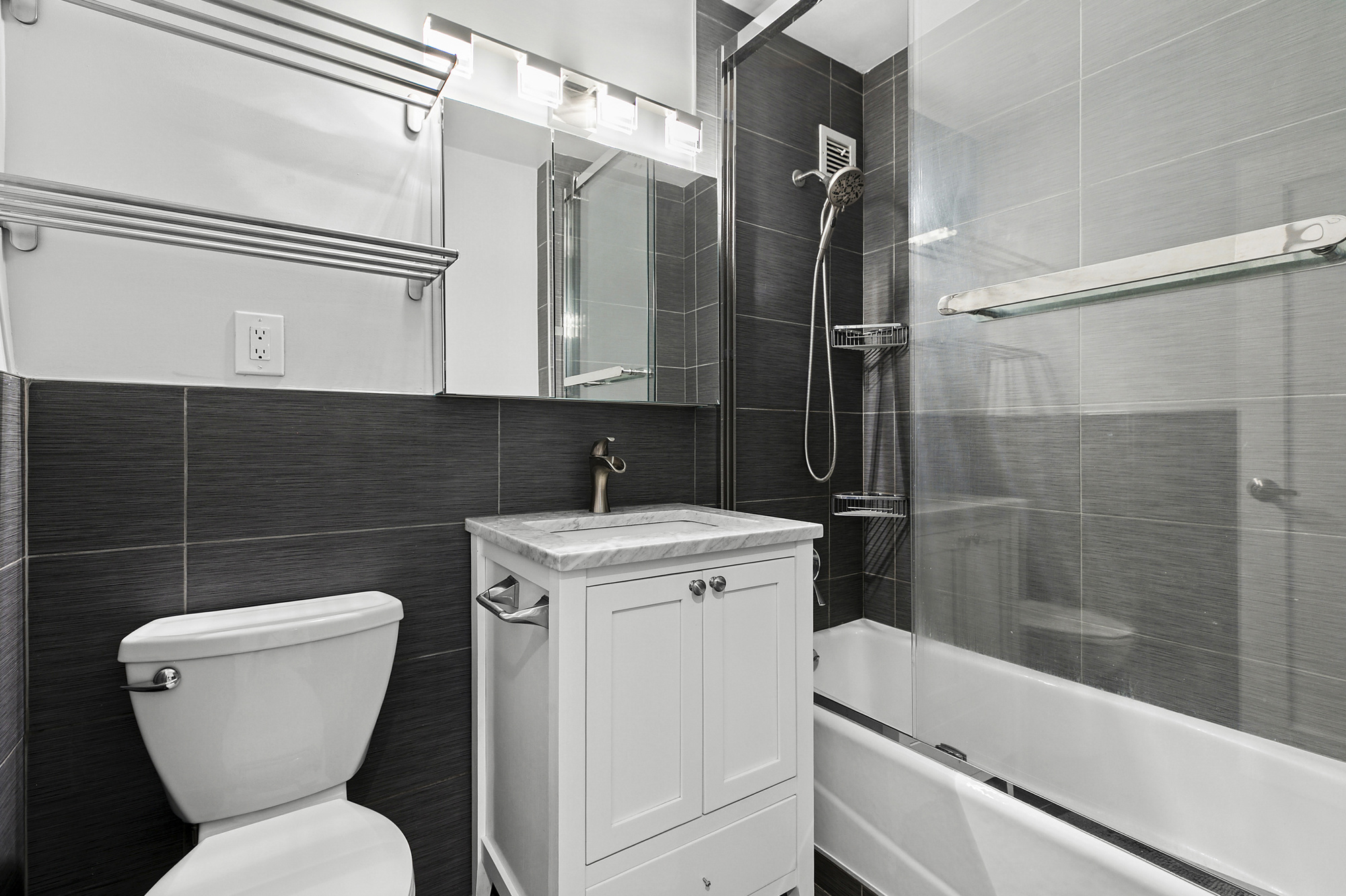 159 West 53rd Street, Unit 11D Manhattan, NY 10019 - Photo 5 of 9 a bathroom with a toilet sink and mirror