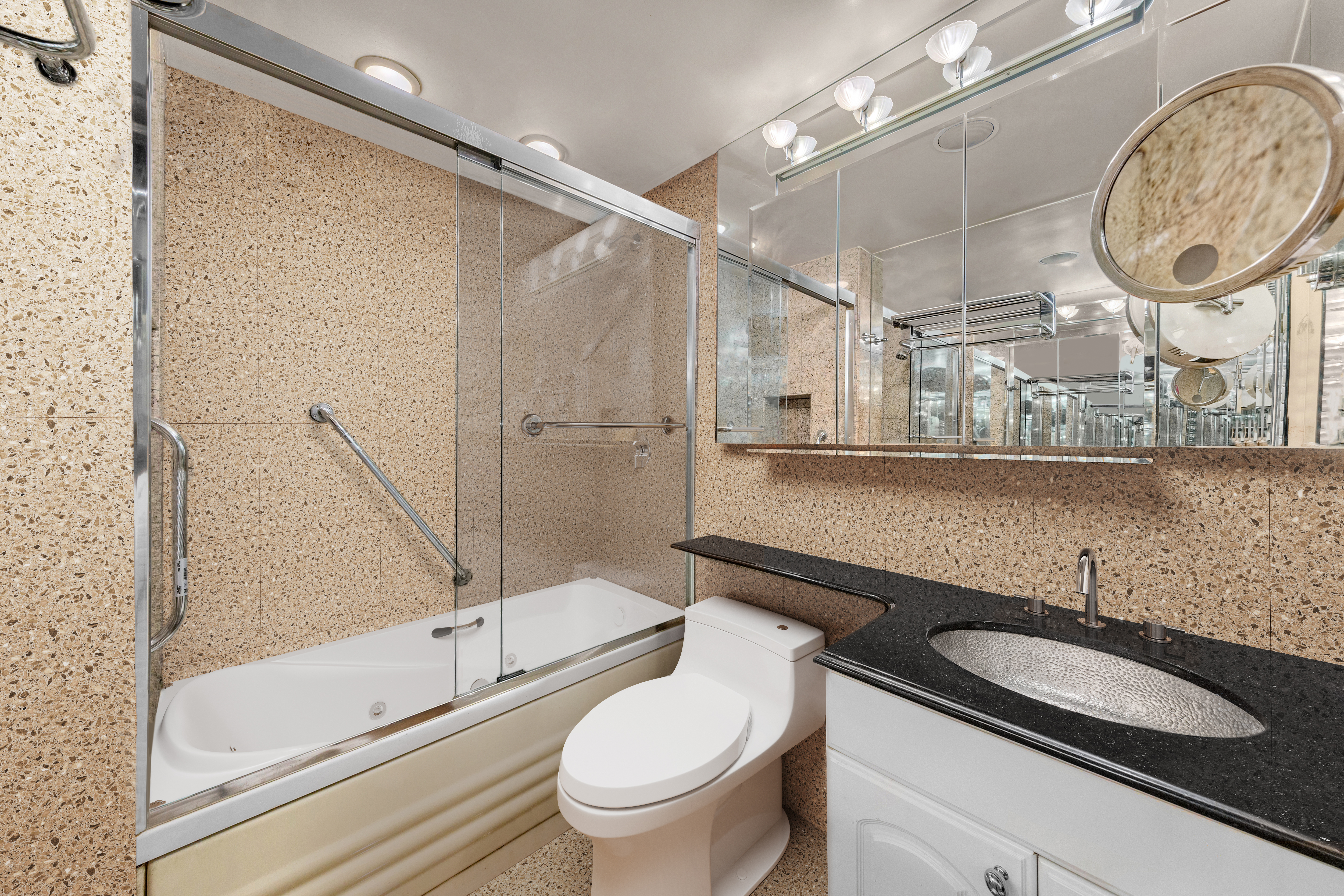 50 Sutton Place South, Unit 9F Manhattan, NY 10022 - Photo 8 of 10 a bathroom with a granite countertop sink mirror vanity and toilet