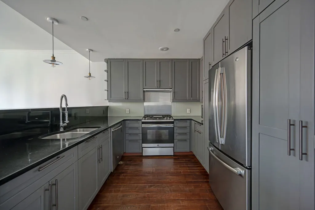a kitchen with granite countertop a refrigerator and a sink