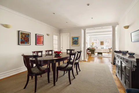 a view of a dining room and livingroom with furniture wooden floor and a rug