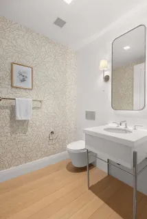 a bathroom with a toilet a sink and mirror