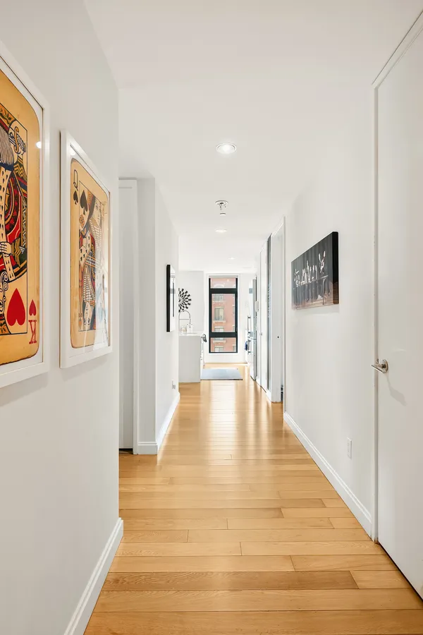 a view of a hallway with wooden floor and dining room