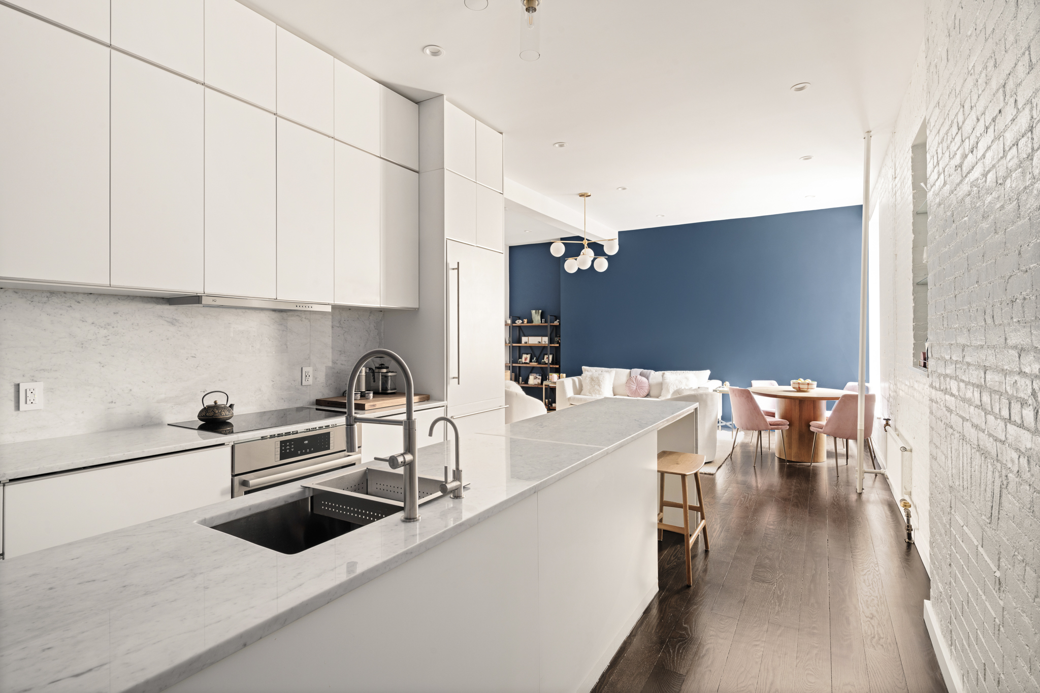 23 East 10th Street, Unit 508 Manhattan, NY 10003 - Photo 3 of 21 a kitchen with stainless steel appliances a stove a sink a refrigerator and white cabinets with wooden floor