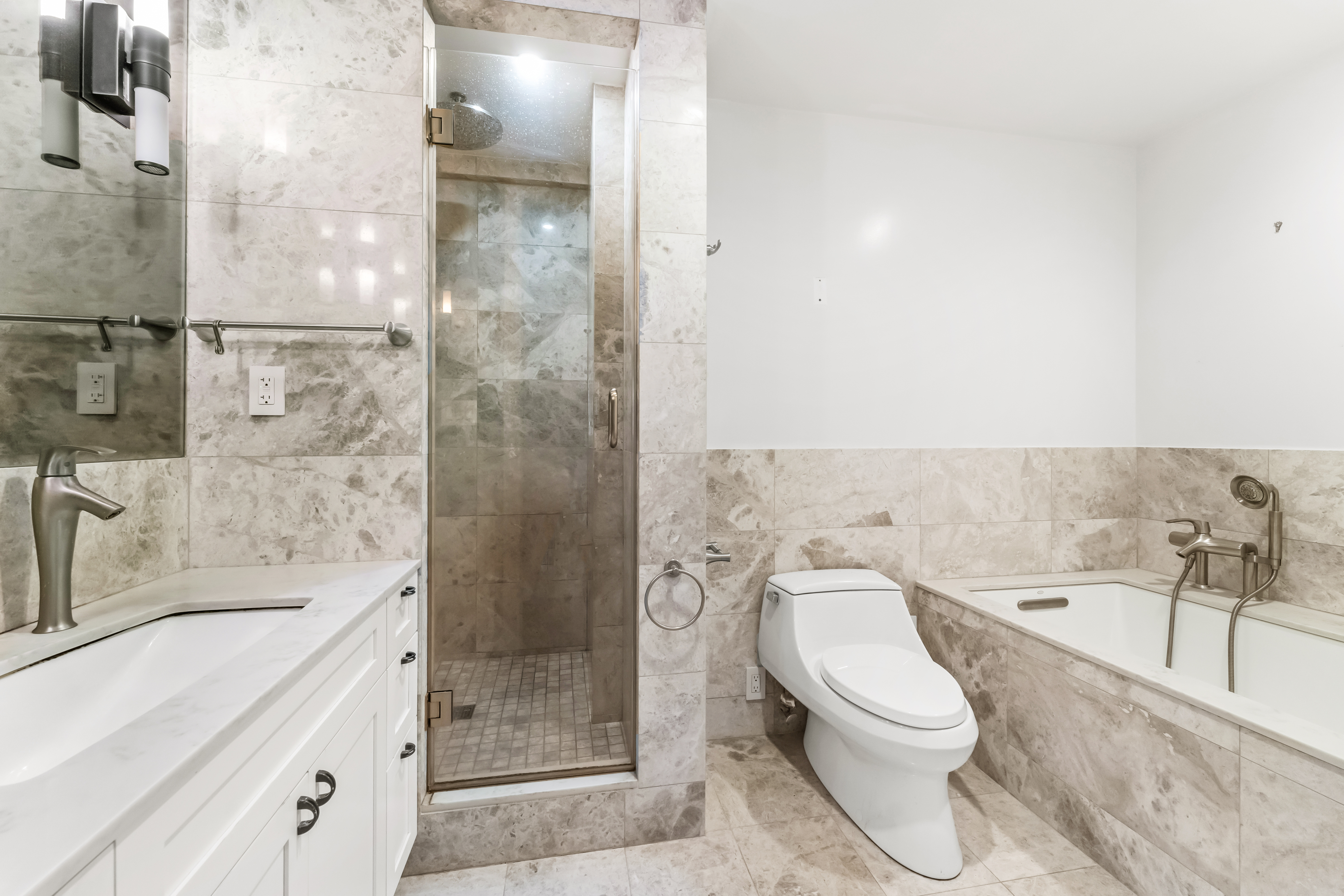 20 East 68th Street, Unit 11C Manhattan, NY 10065 - Photo 5 of 11 a bathroom with a bathtub shower sink vanity and toilet