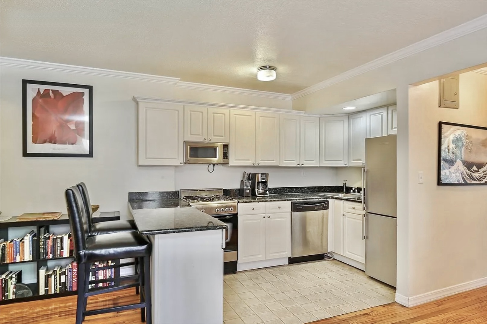 4523 Broadway, Unit 5D Manhattan, NY 10040 - Photo 2 of 10 a kitchen with stainless steel appliances granite countertop a stove top oven a sink a refrigerator white cabinets and wooden floor