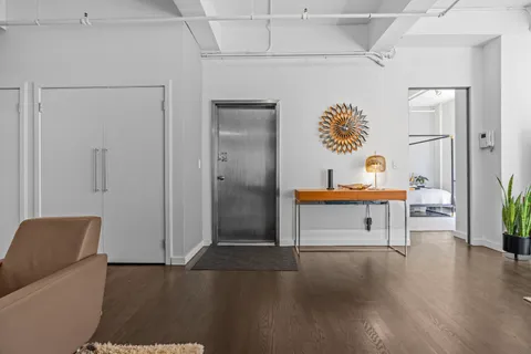 a hallway view with furniture and wooden floor