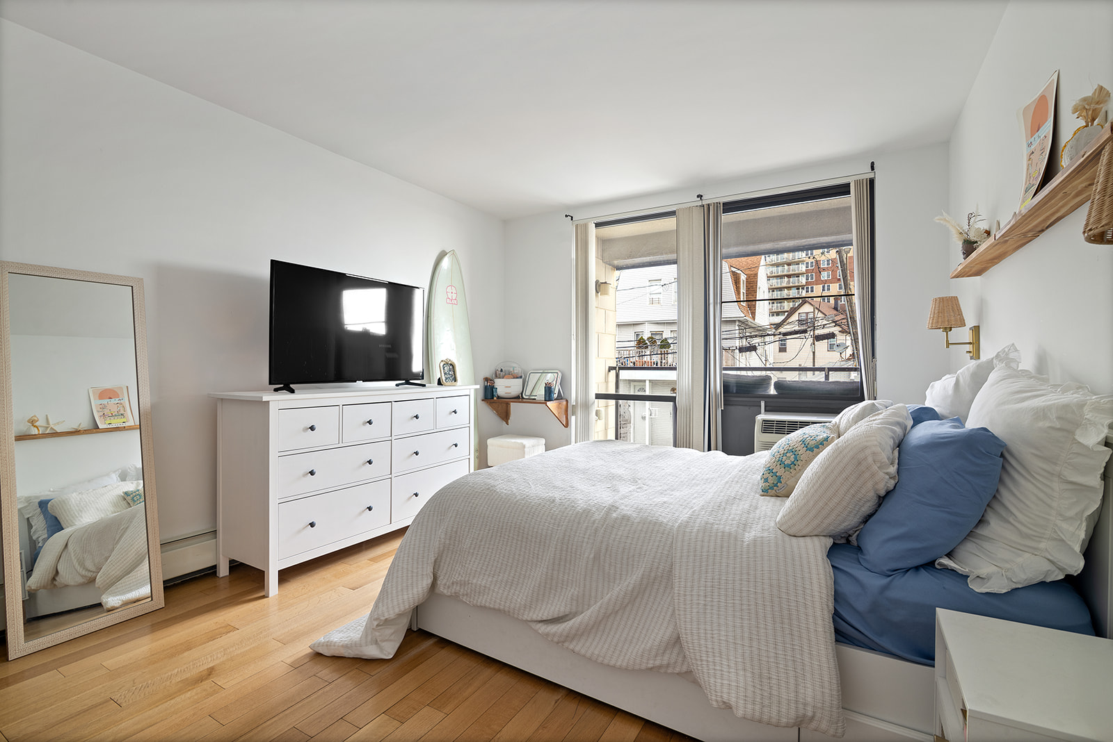 91-16 Shore Front Parkway, Unit 2F Queens, NY 11693 - Photo 5 of 9 a bedroom with a bed and a flat screen tv