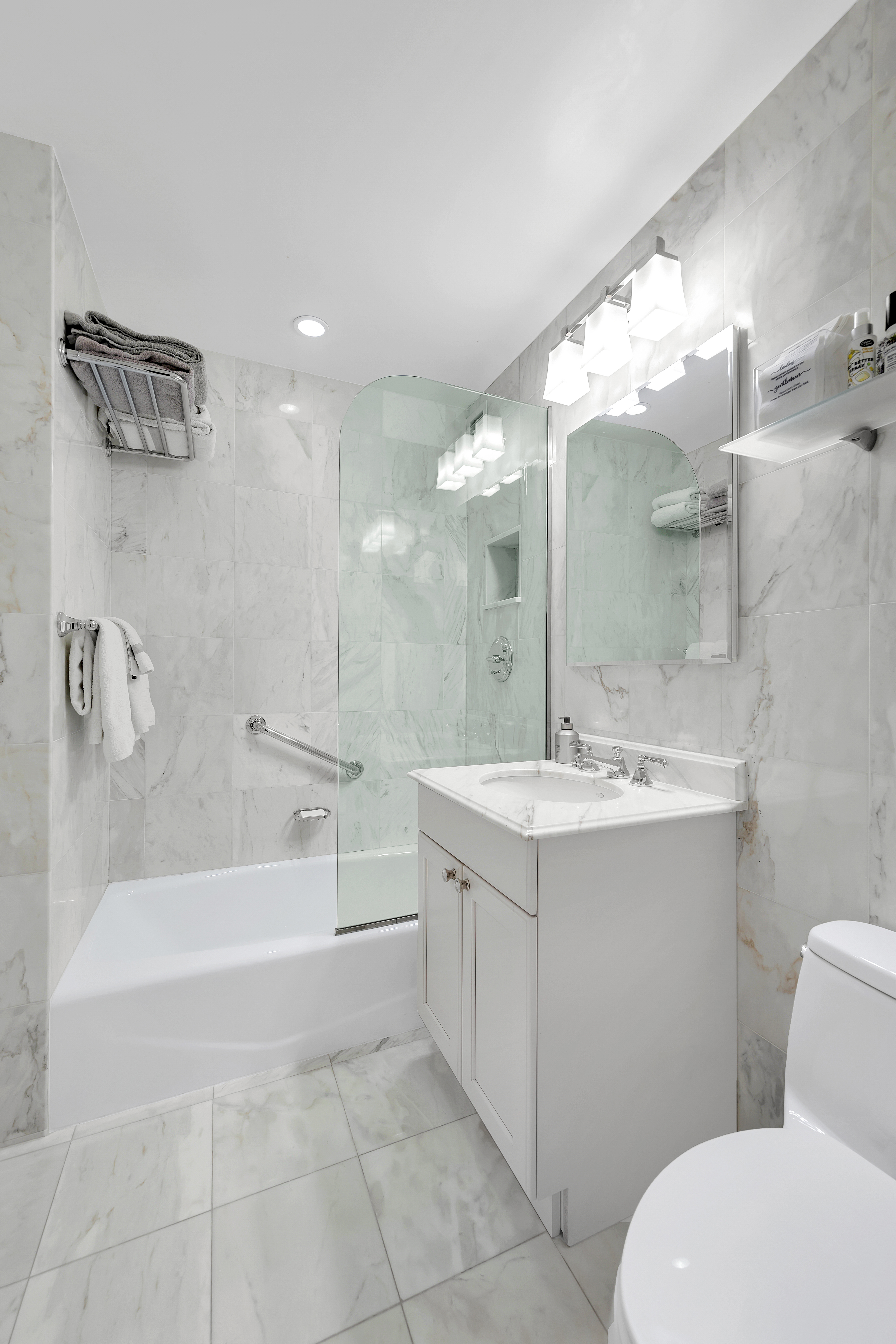 900 Park Avenue, Unit 10B Manhattan, NY 10075 - Photo 7 of 11 a bathroom with a sink a toilet and shower