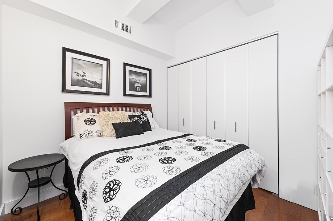 80 John Street, Unit 11E Manhattan, NY 10038 - Photo 4 of 9 a bedroom with a bed and painting on the wall