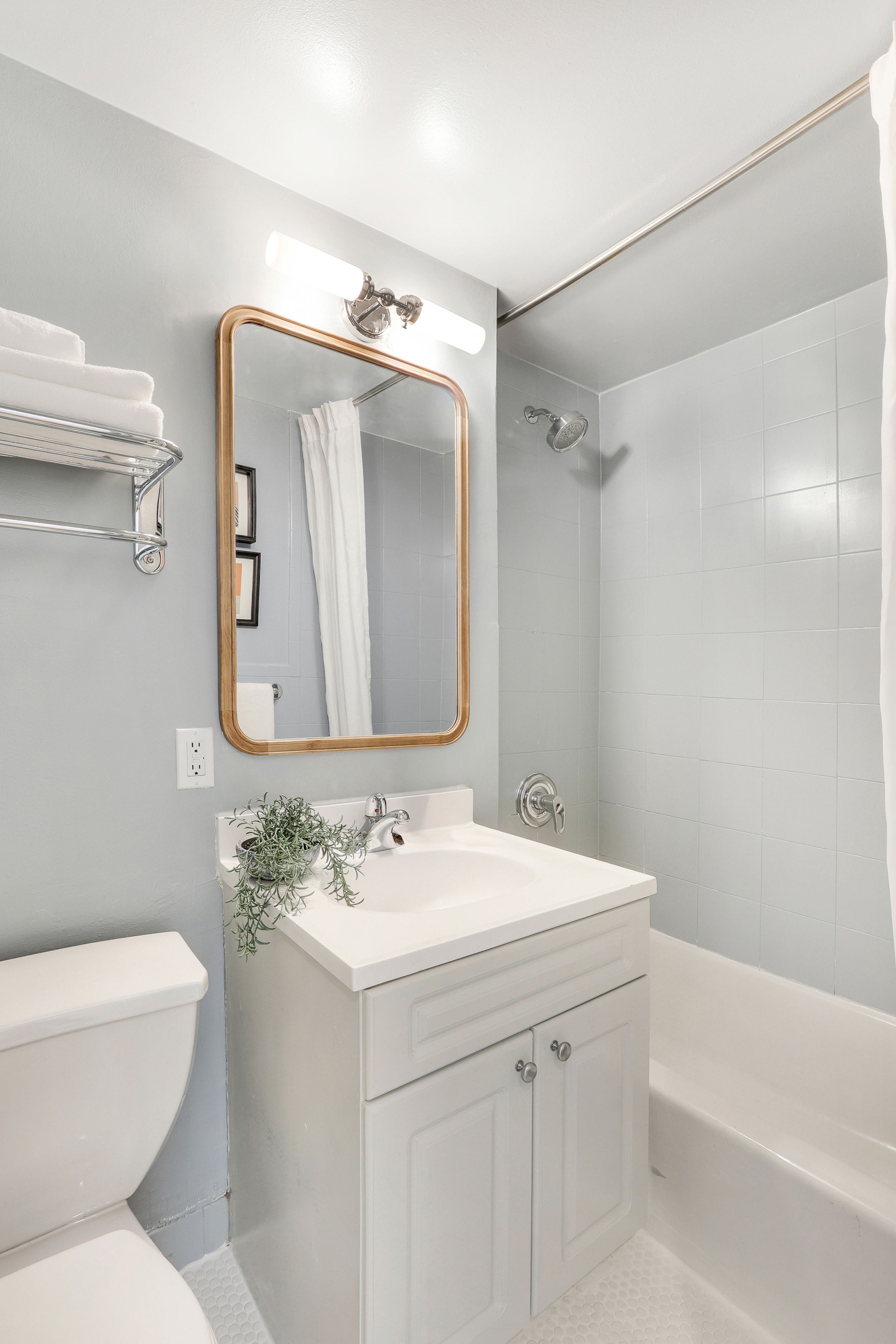304 West 88th Street, Unit 4B Manhattan, NY 10024 - Photo 7 of 8 a bathroom with a sink toilet vanity mirror and tub