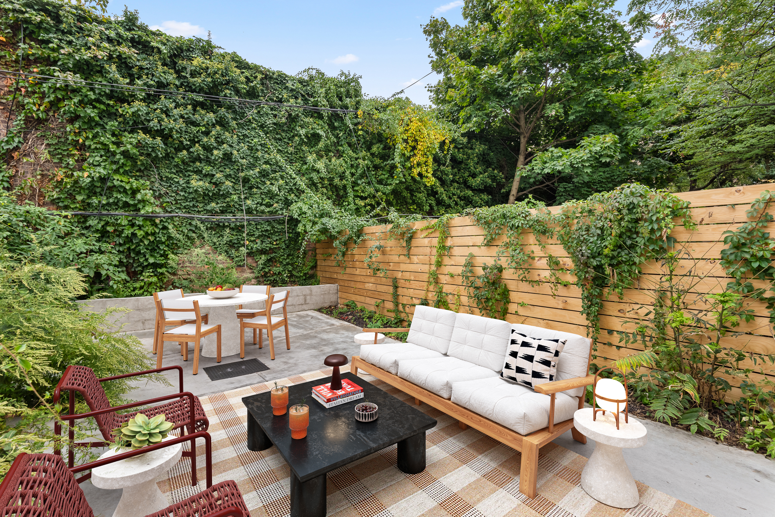 a view of a patio with couches table and chairs and potted plants