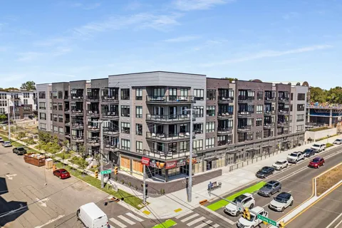 a roof deck with table and chairs and potted plants