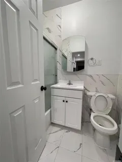 a bathroom with a toilet sink and mirror