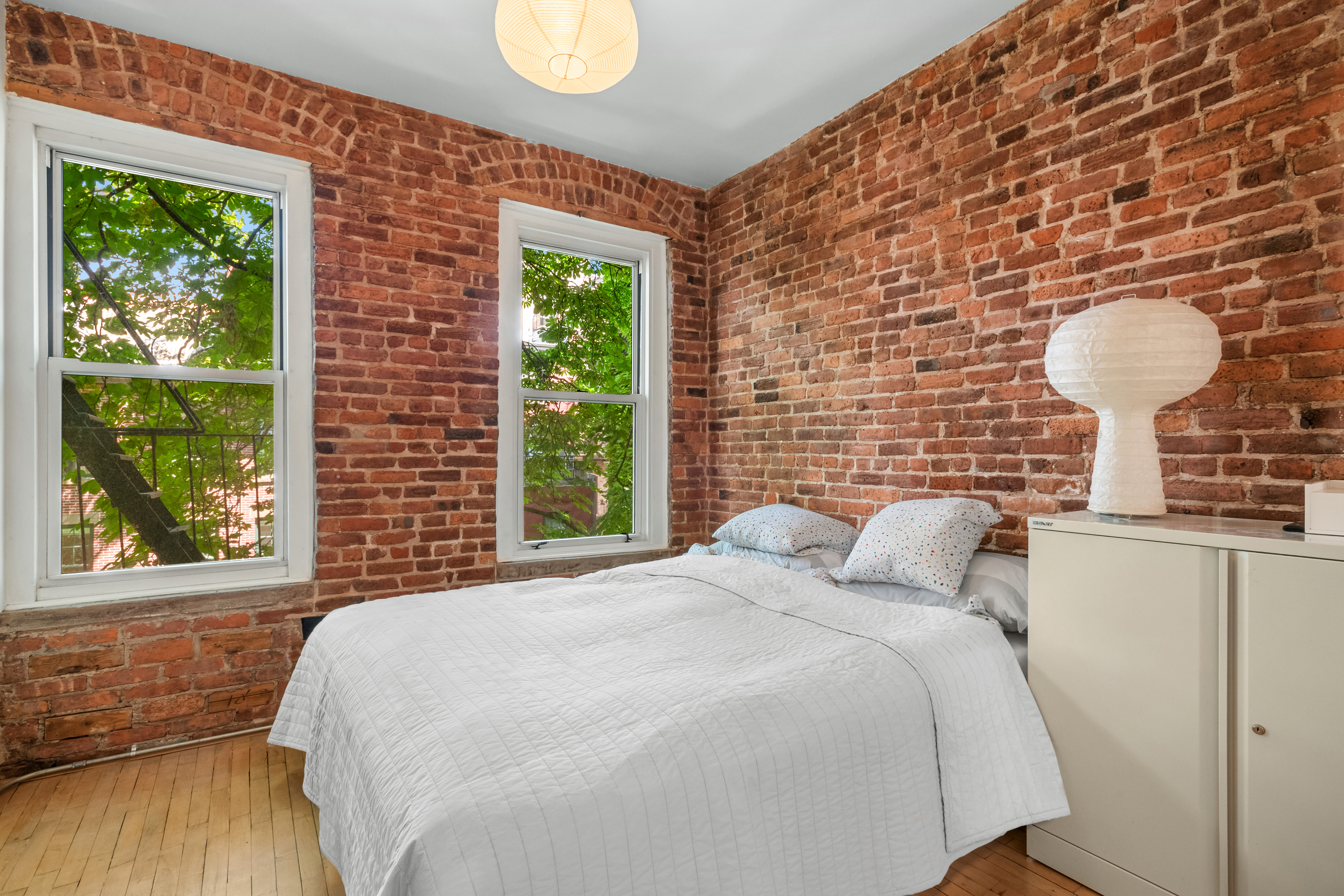 77 Perry Street, Unit 3D Manhattan, NY 10014 - Photo 7 of 11 a bedroom with a bed and a lamp next to a window