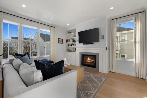 a living room with furniture a fireplace and a flat screen tv
