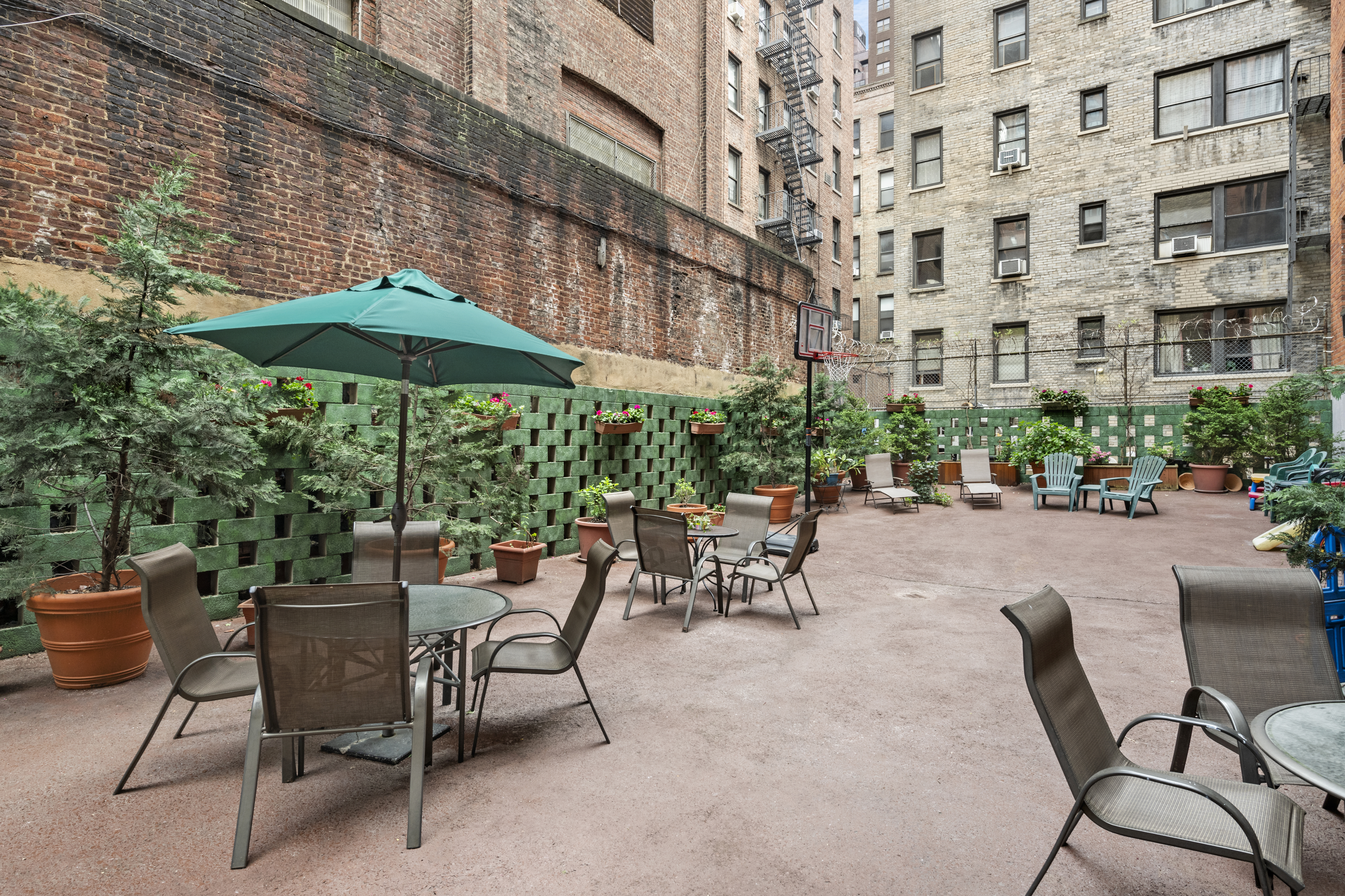 347 East 53rd Street, Unit 2B Manhattan, NY 10022 - Photo 6 of 7 a view of a patio with a table and chairs under an umbrella
