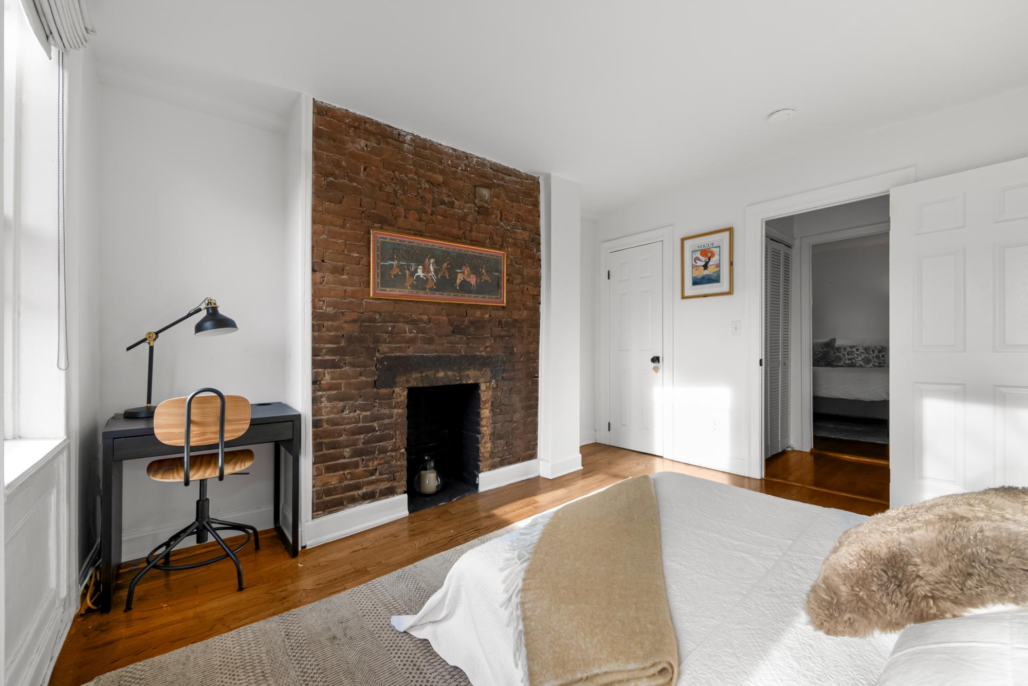 504 East 6th Street, Unit 5 Manhattan, NY 10009 - Photo 7 of 11 a bedroom with a bed and a fireplace