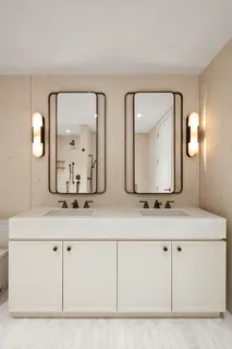 a bathroom with double vanity sinks and a mirror