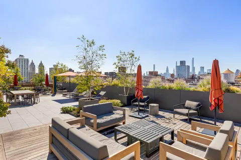 a view of a rooftop with chairs and a table