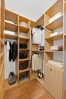 a view of walk in closet with clothes and shoes