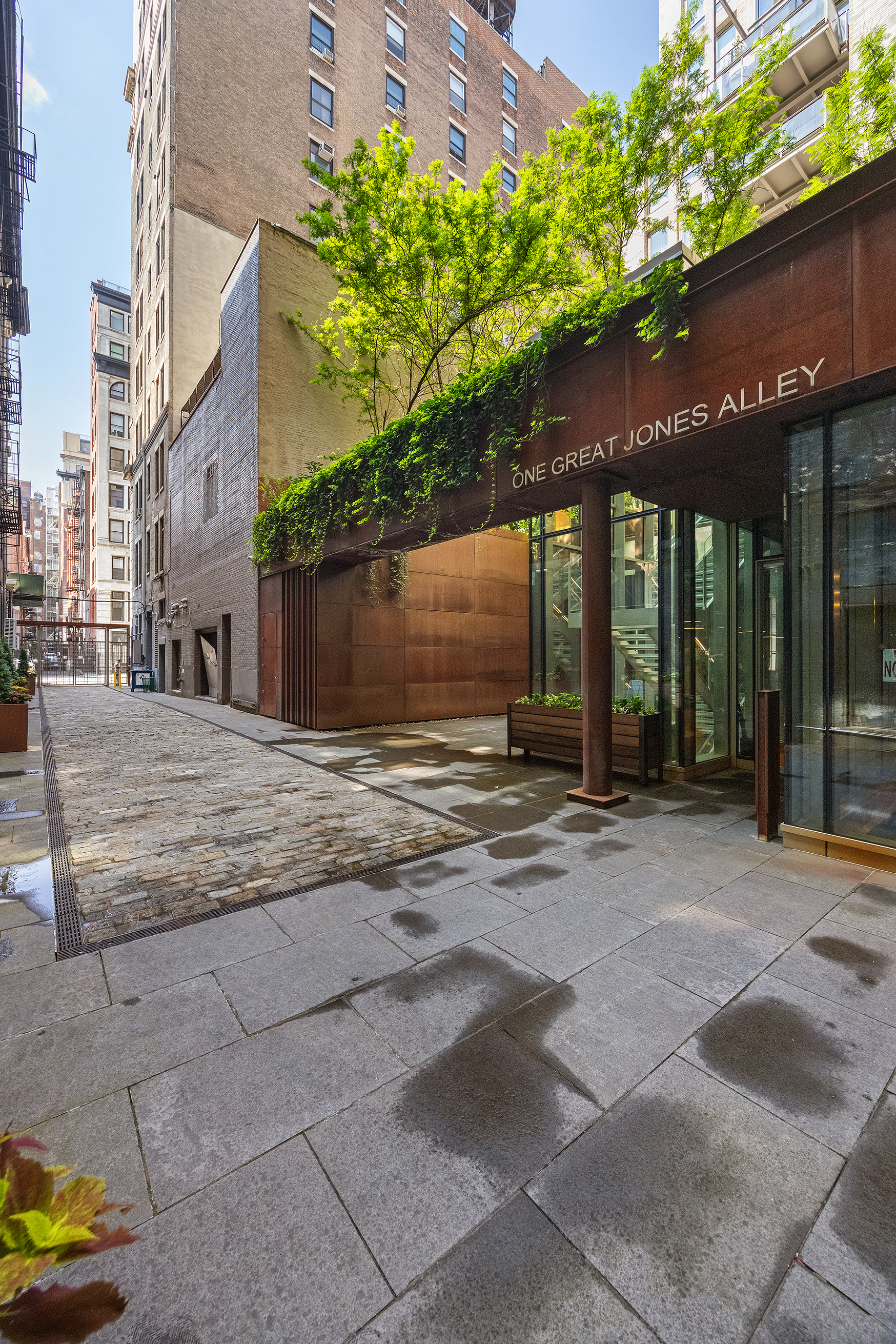 1 Great Jones Alley, Unit 10 Manhattan, NY 10012 - Photo 34 of 41 a backyard of a house with large trees and plants