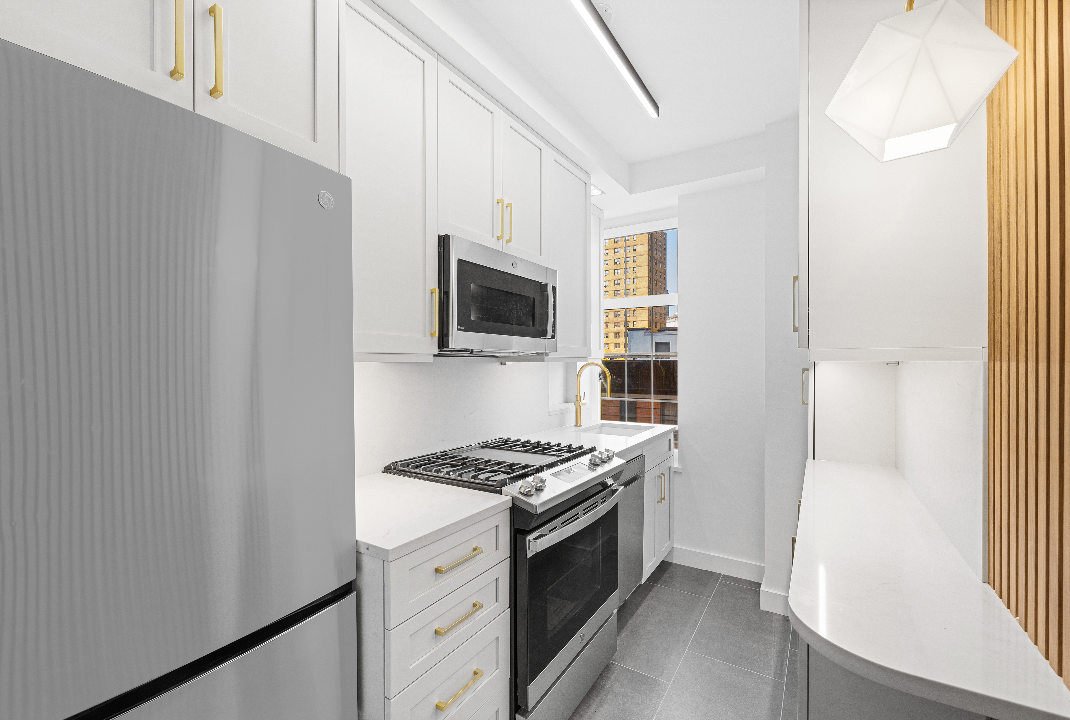 410 West 24th Street, Unit 8F Manhattan, NY 10011 - Photo 3 of 16 a kitchen with stainless steel appliances a refrigerator and a stove top oven