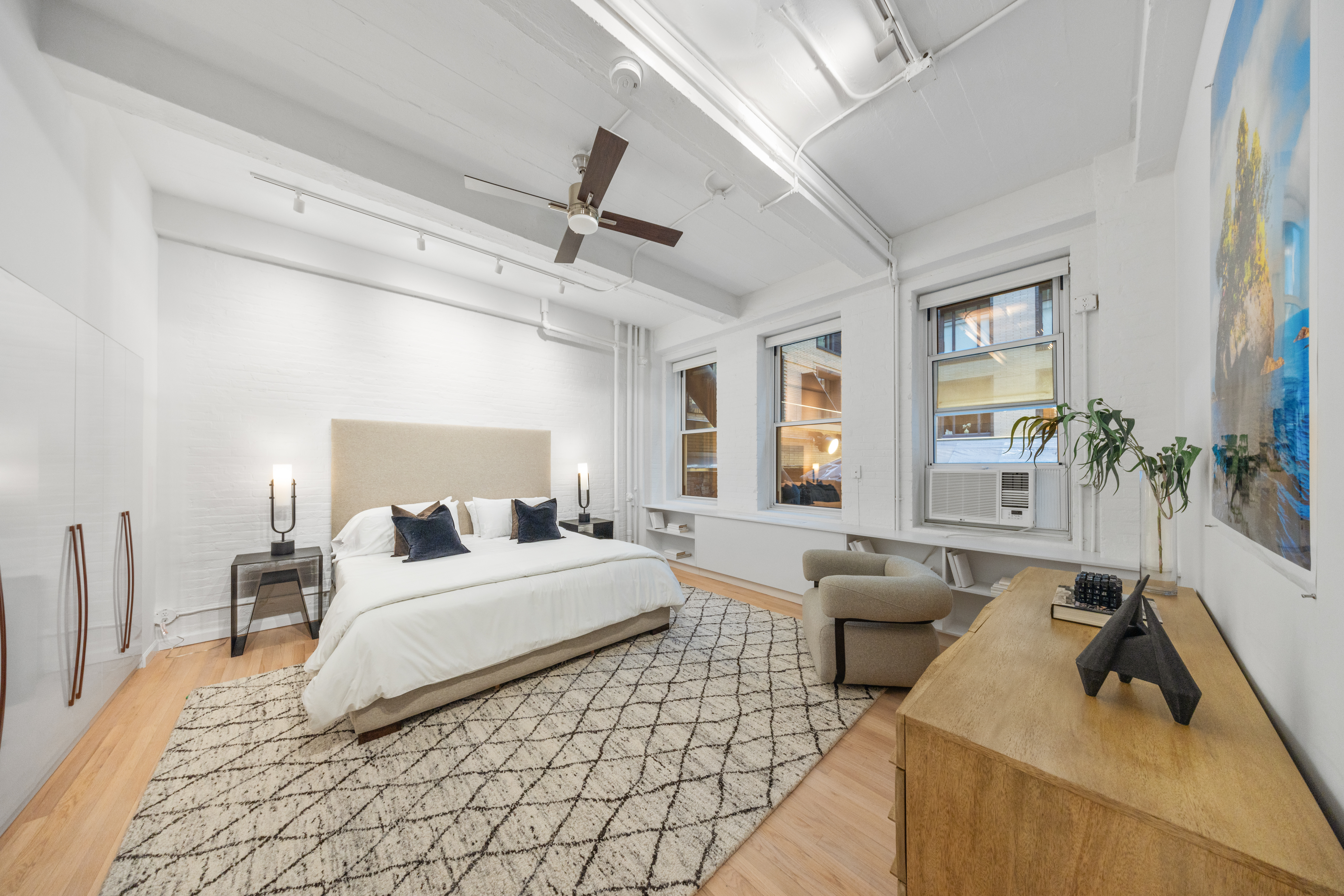 95 Vandam Street, Unit 2R Manhattan, NY 10013 - Photo 15 of 21 a spacious bedroom with a bed a couch and a large window