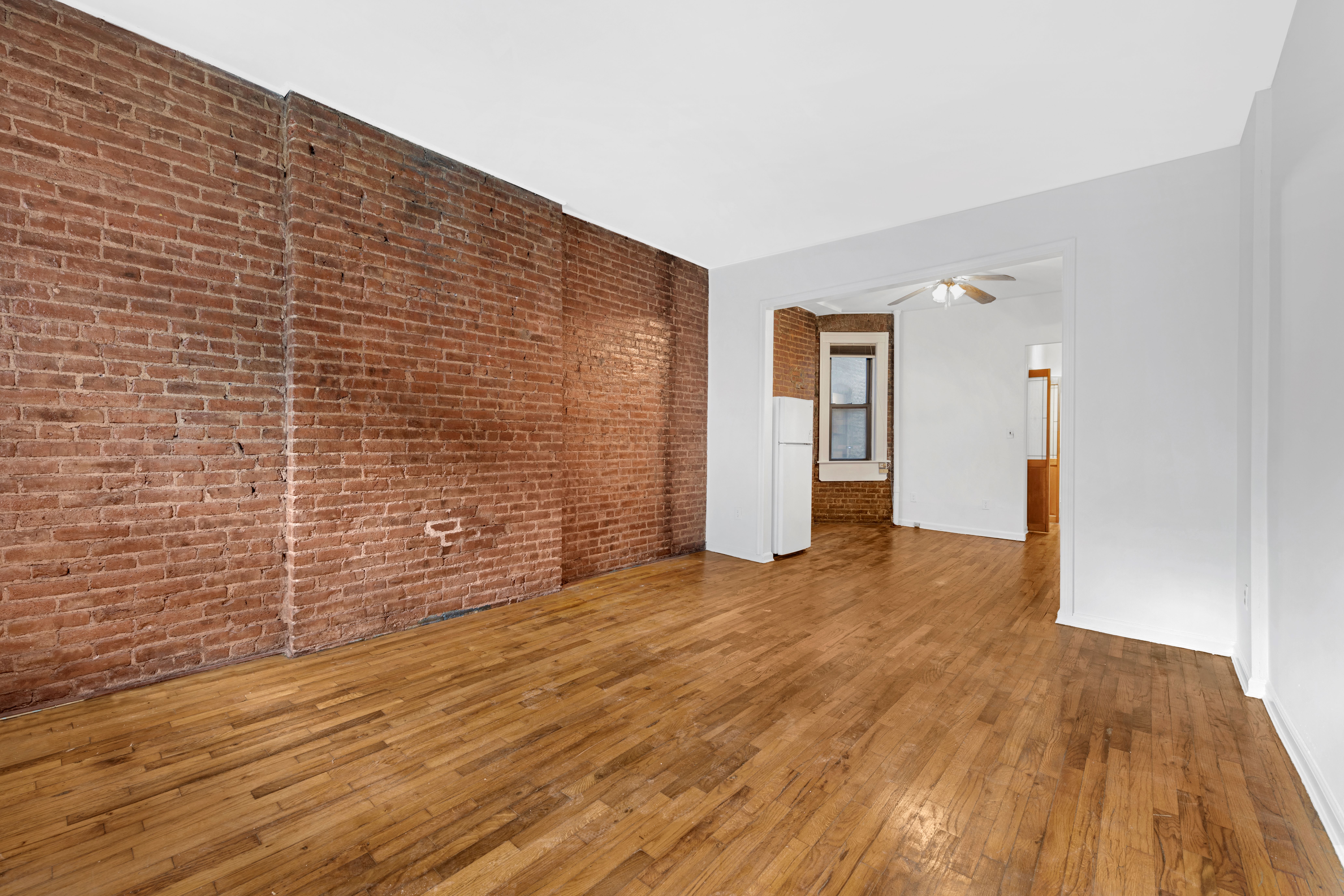 433 West 54th Street, Unit 1 Manhattan, NY 10019 - Photo 8 of 9 a view of an empty room with wooden floor