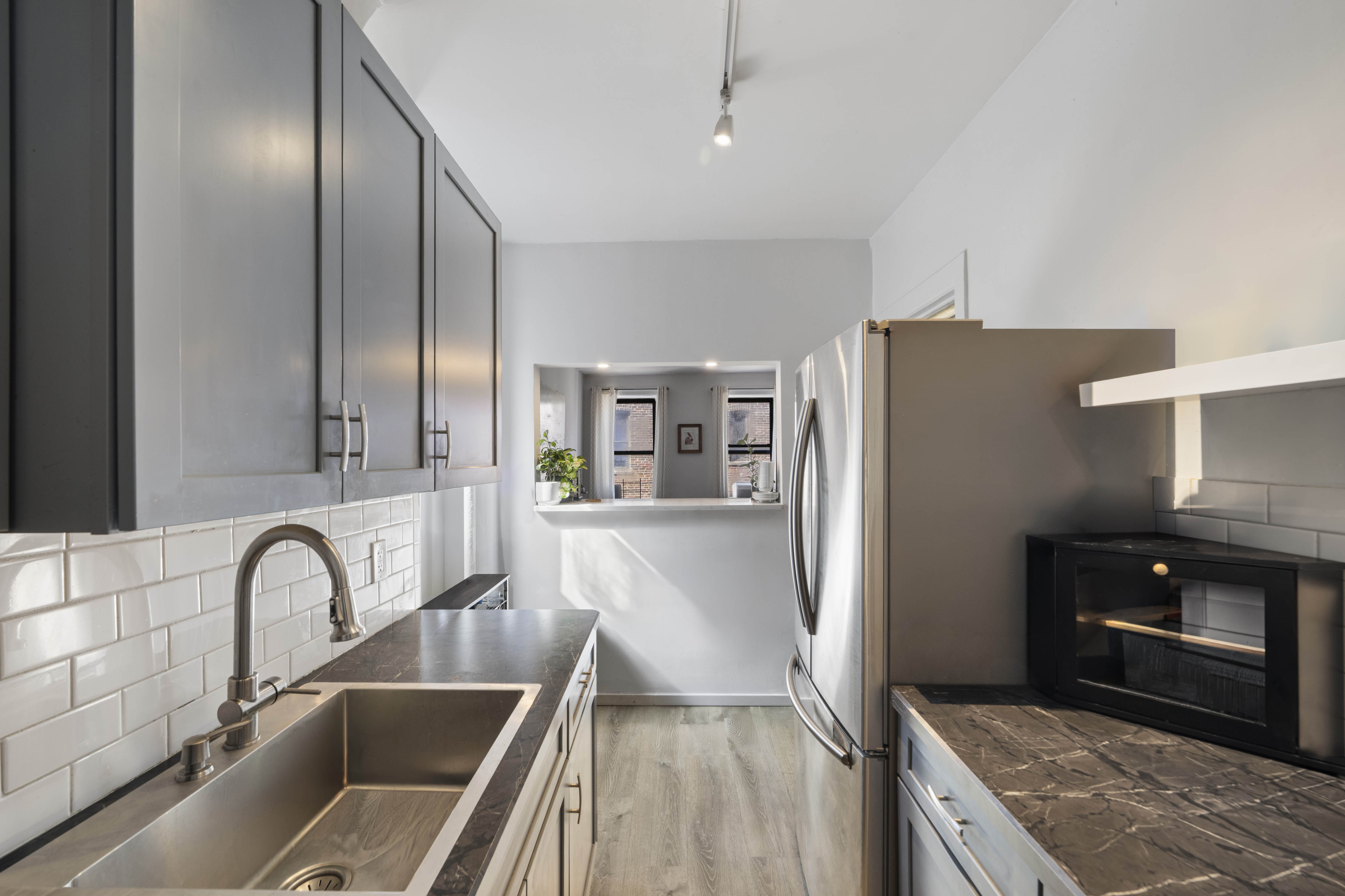 2199 Holland Avenue, Unit 5P Bronx, NY 10462 - Photo 5 of 11 a kitchen with stainless steel appliances granite countertop a refrigerator a stove and a sink with wooden floor