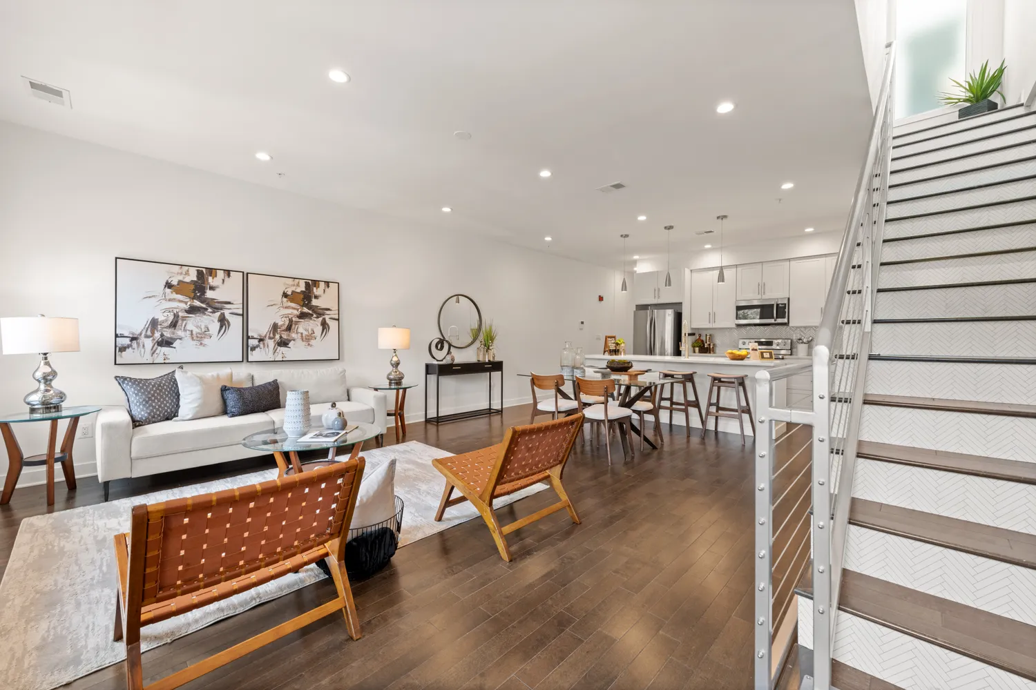 a living room with furniture and kitchen view with wooden floor
