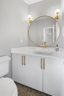a bathroom with a sink a toilet and mirror