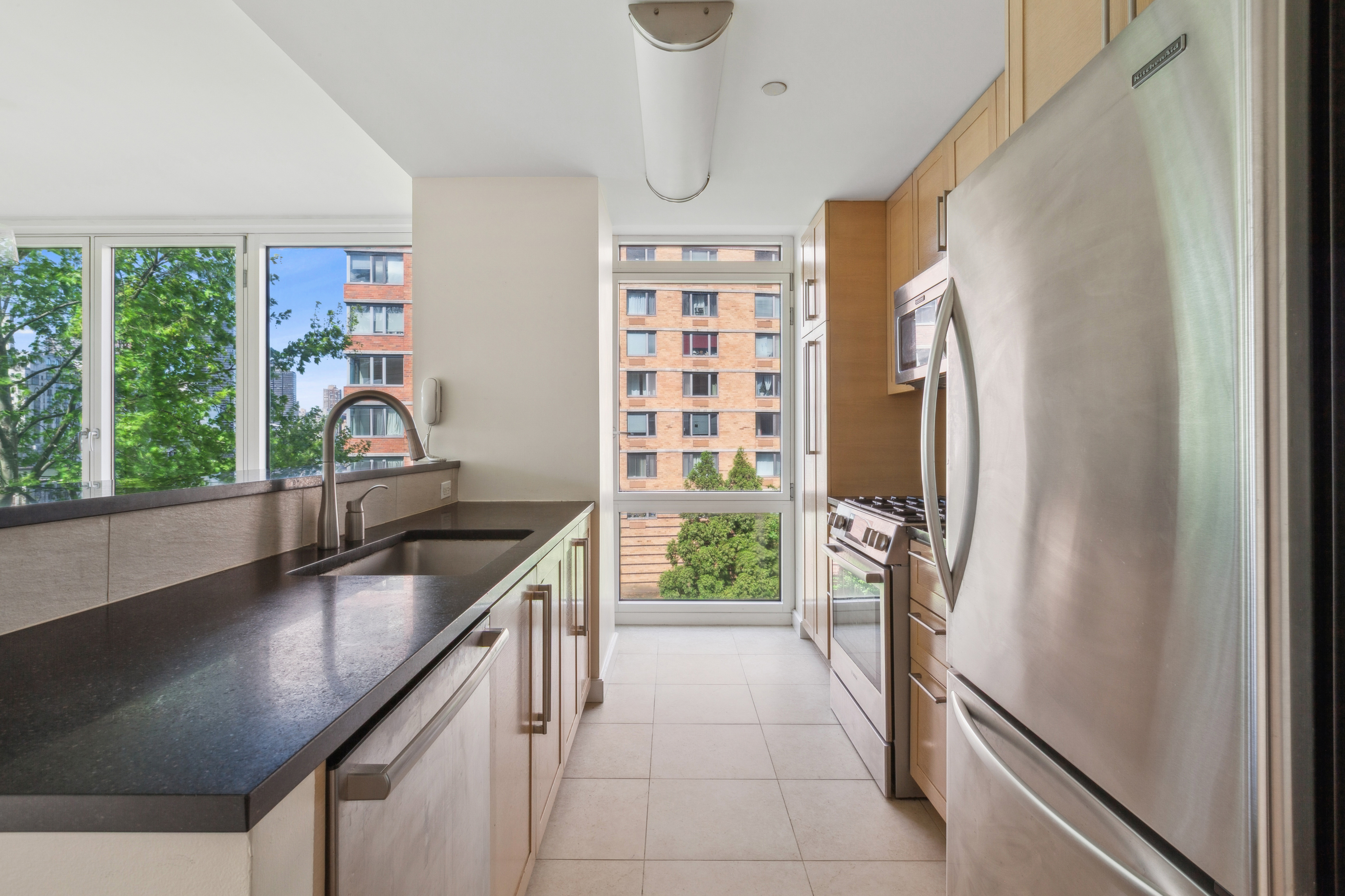 415 Main Street, Unit 4G Manhattan, NY 10044 - Photo 4 of 18 a kitchen with a sink stove and refrigerator