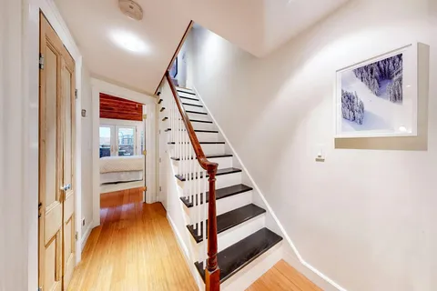 a view of a hallway with wooden floor and entryway