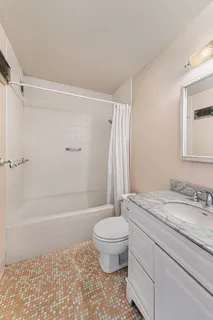a bathroom with a granite countertop sink toilet and shower
