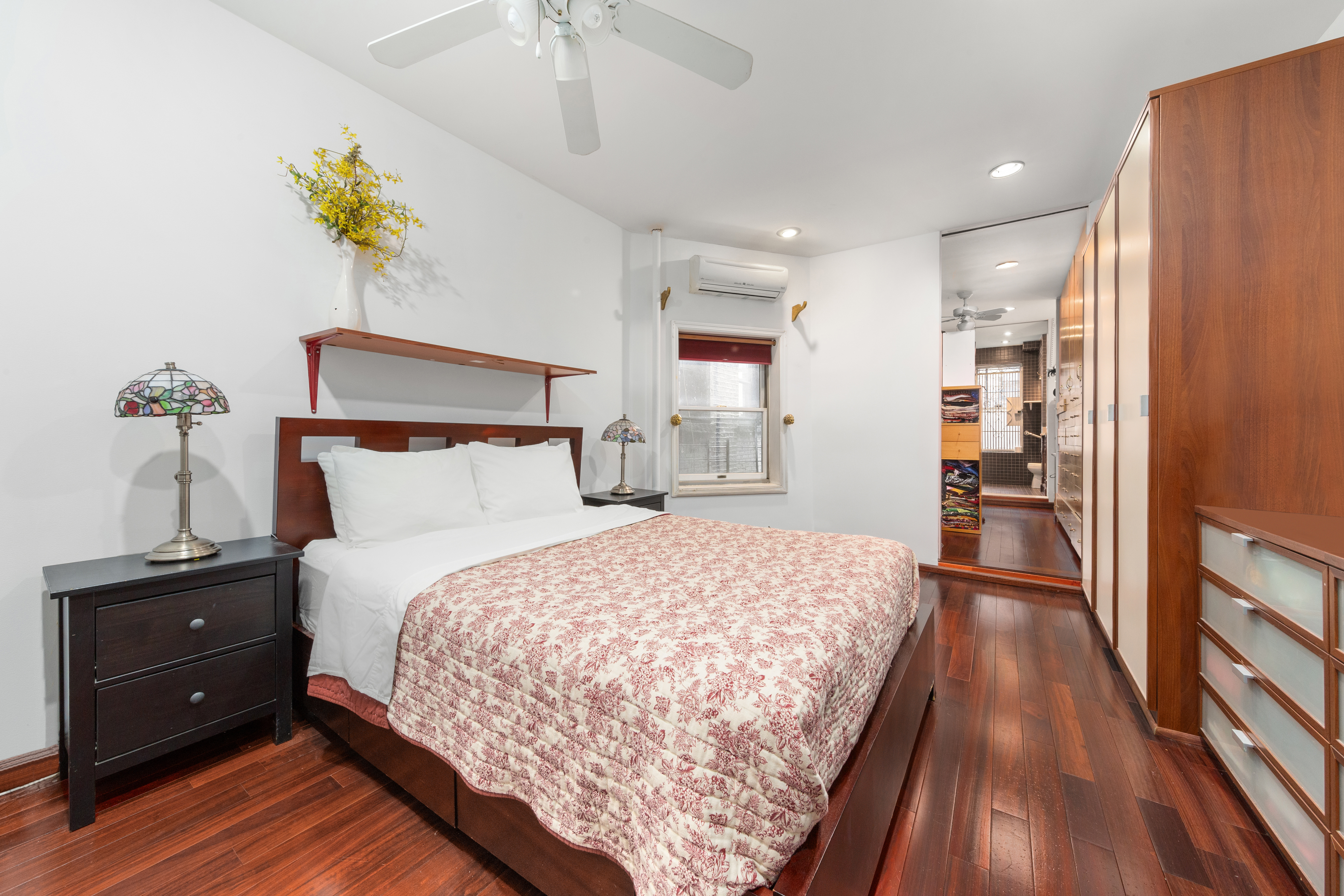 517 East 87th Street, Unit 1 Manhattan, NY 10128 - Photo 6 of 17 a bedroom with a bed and a chandelier