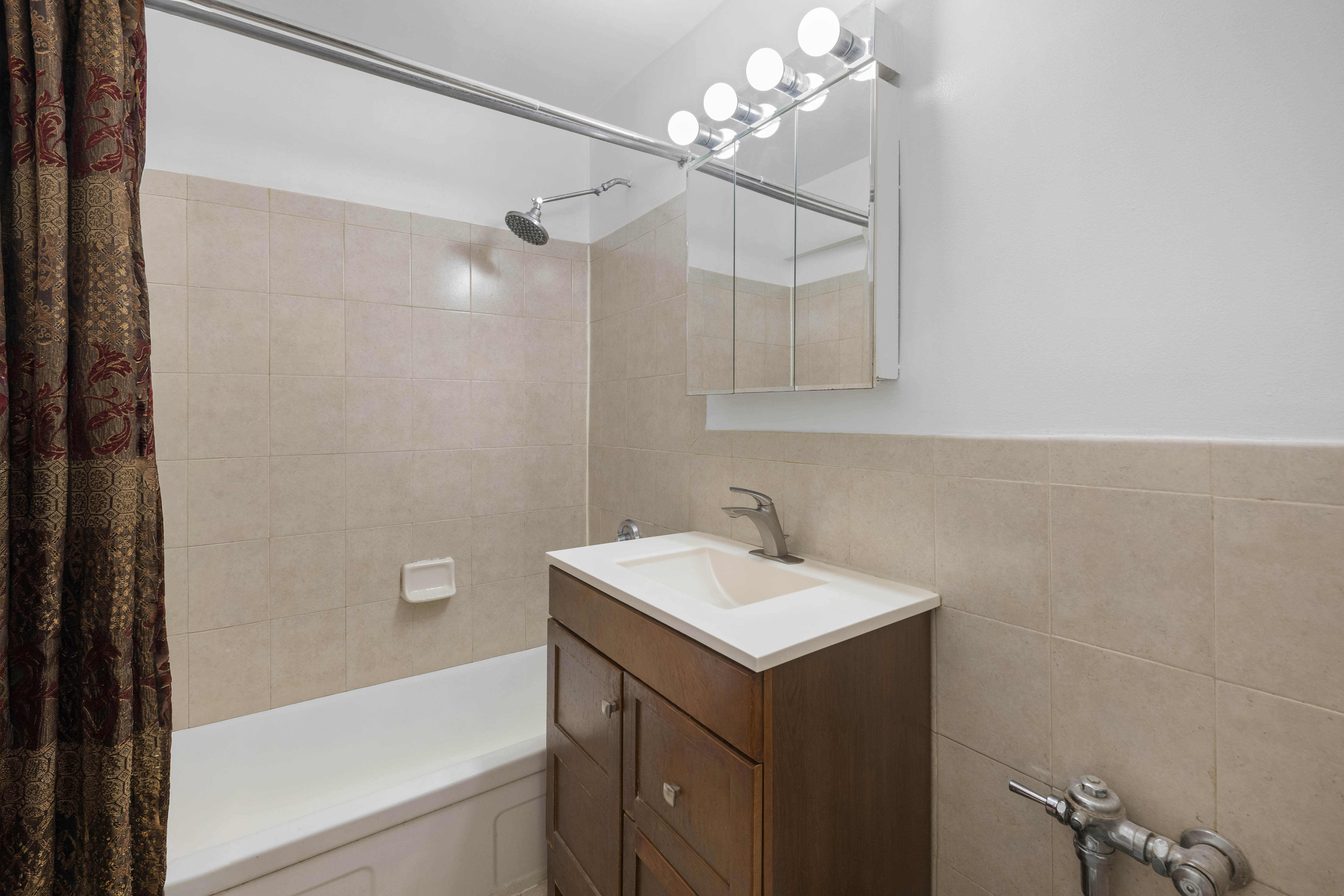 2750 Johnson Avenue, Unit 7G Bronx, NY 10463 - Photo 7 of 12 a bathroom with a sink a mirror and a bathtub
