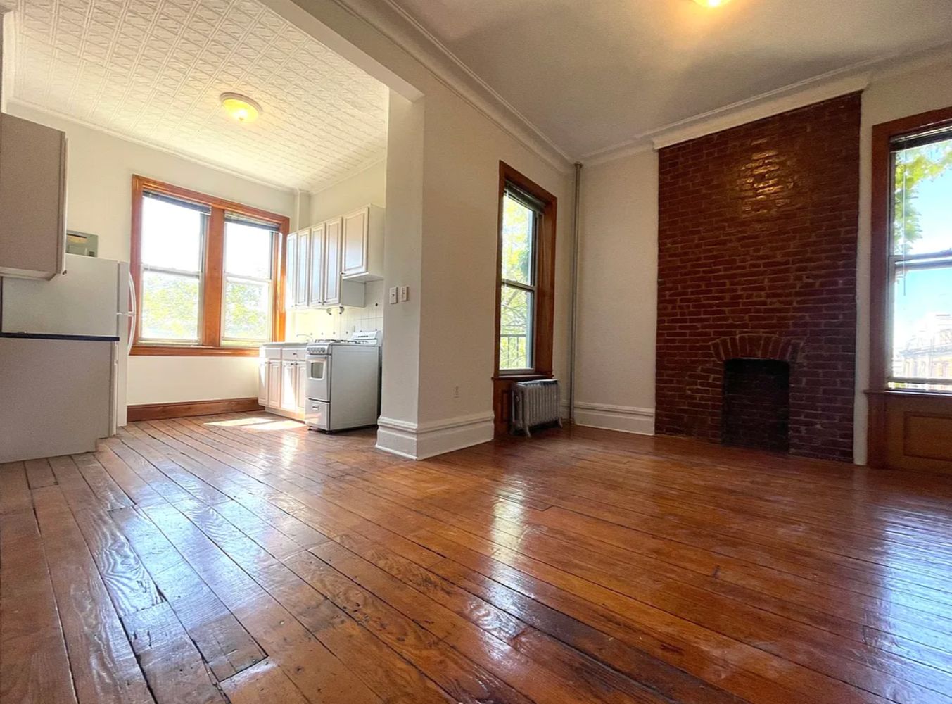 a view of empty room with a fireplace and wooden floor