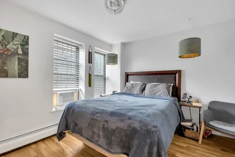 a bedroom with a bed and wooden floor