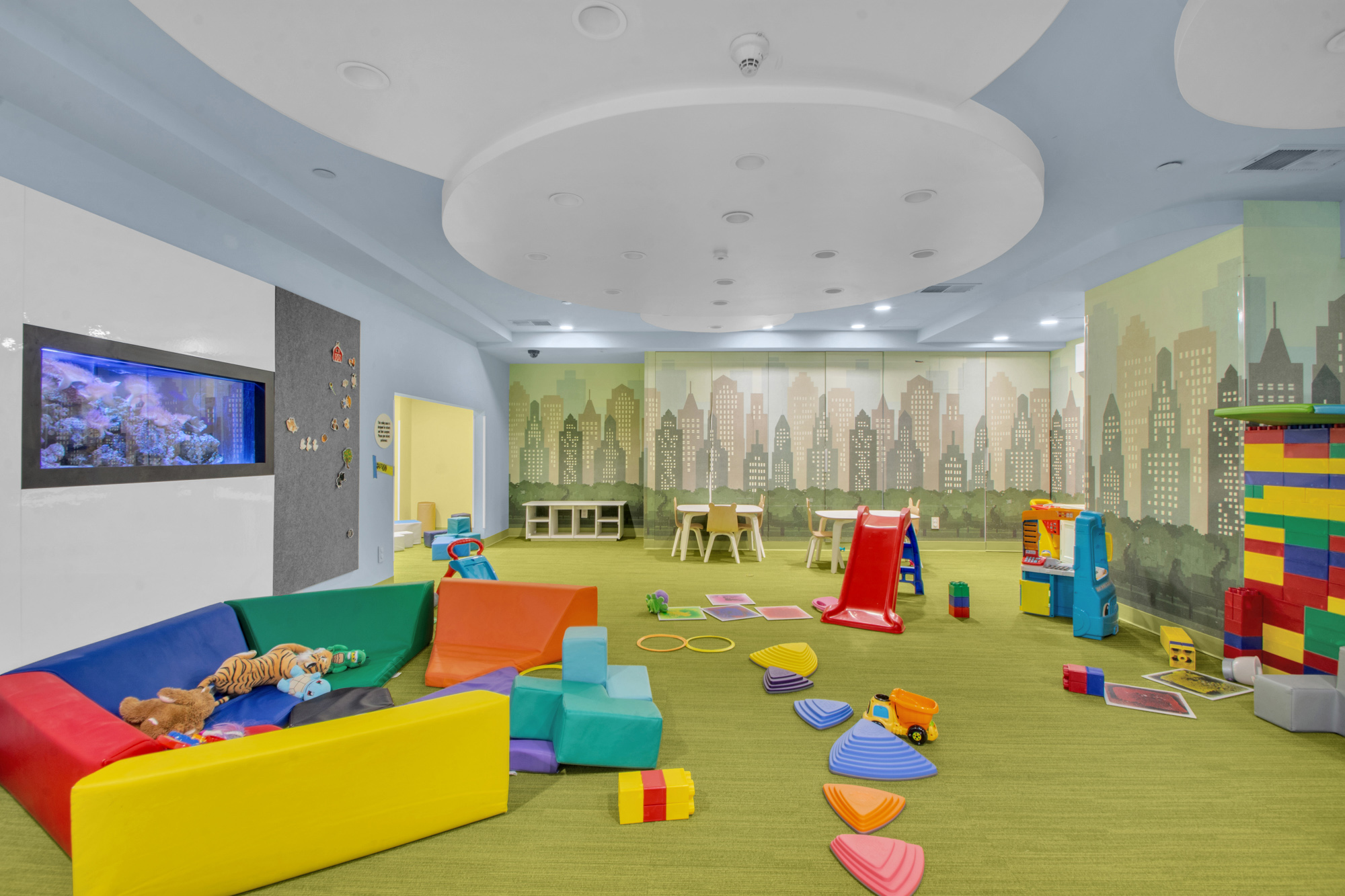 333 Rector Place, Unit 408 Manhattan, NY 10280 - Photo 9 of 12 a playing room with toys and a dining table with chairs