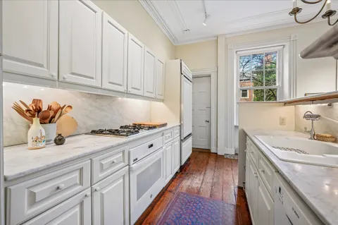a kitchen with granite countertop a sink dishwasher stove and cabinets