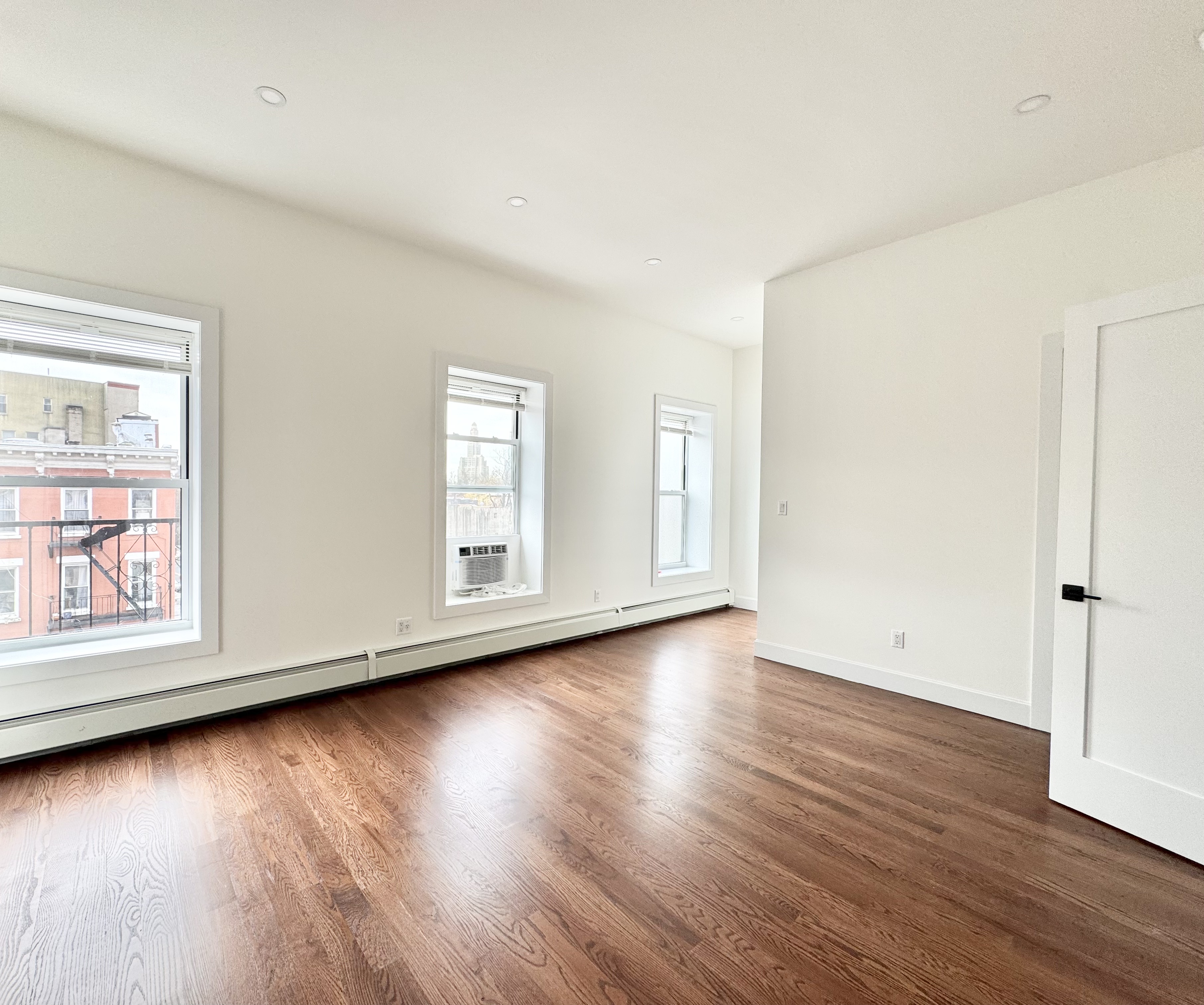 383 Myrtle Avenue, Unit 3 Brooklyn, NY 11205 - Photo 16 of 21 an empty room with wooden floor and windows with curtains