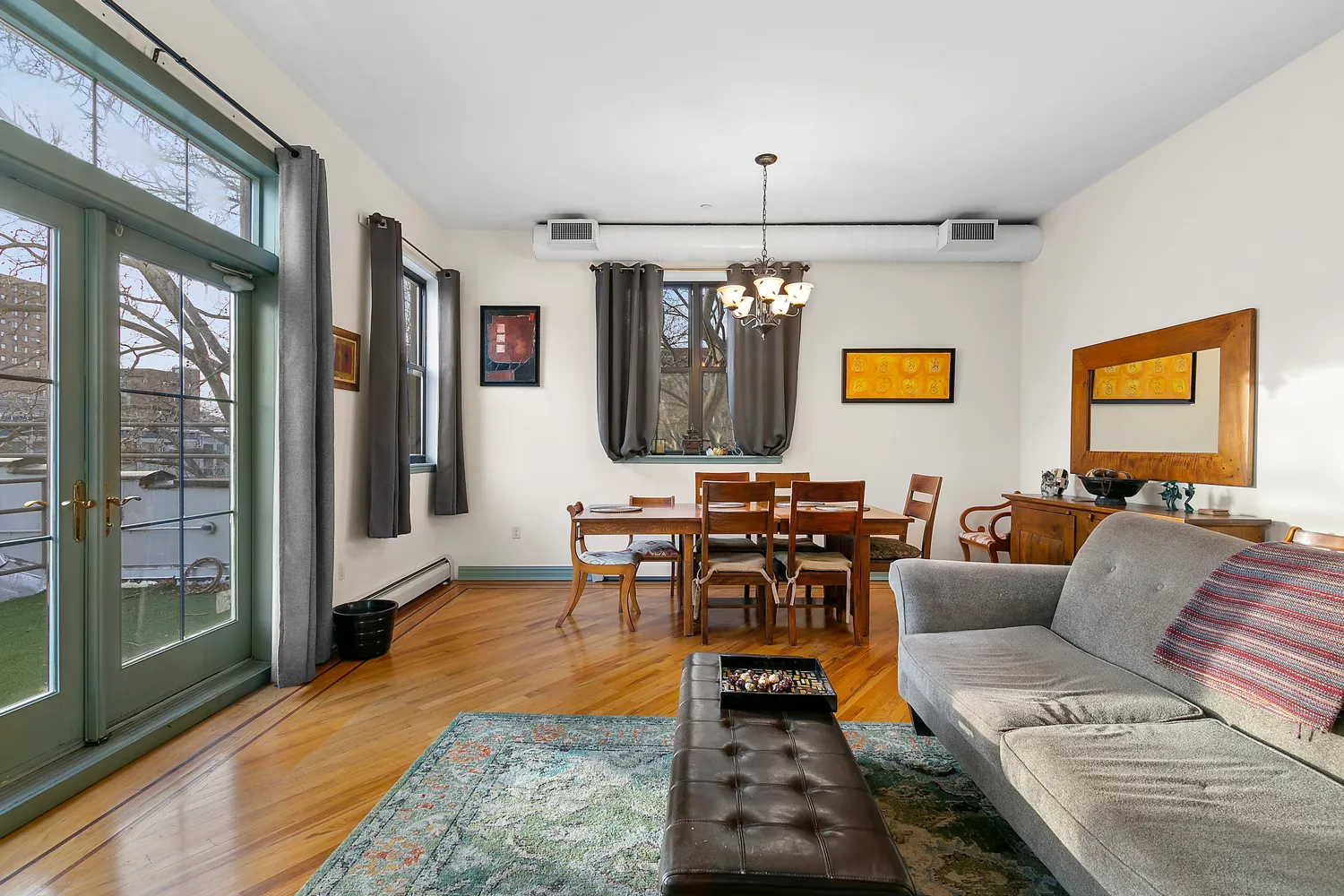 a living room with furniture a large window and wooden floor