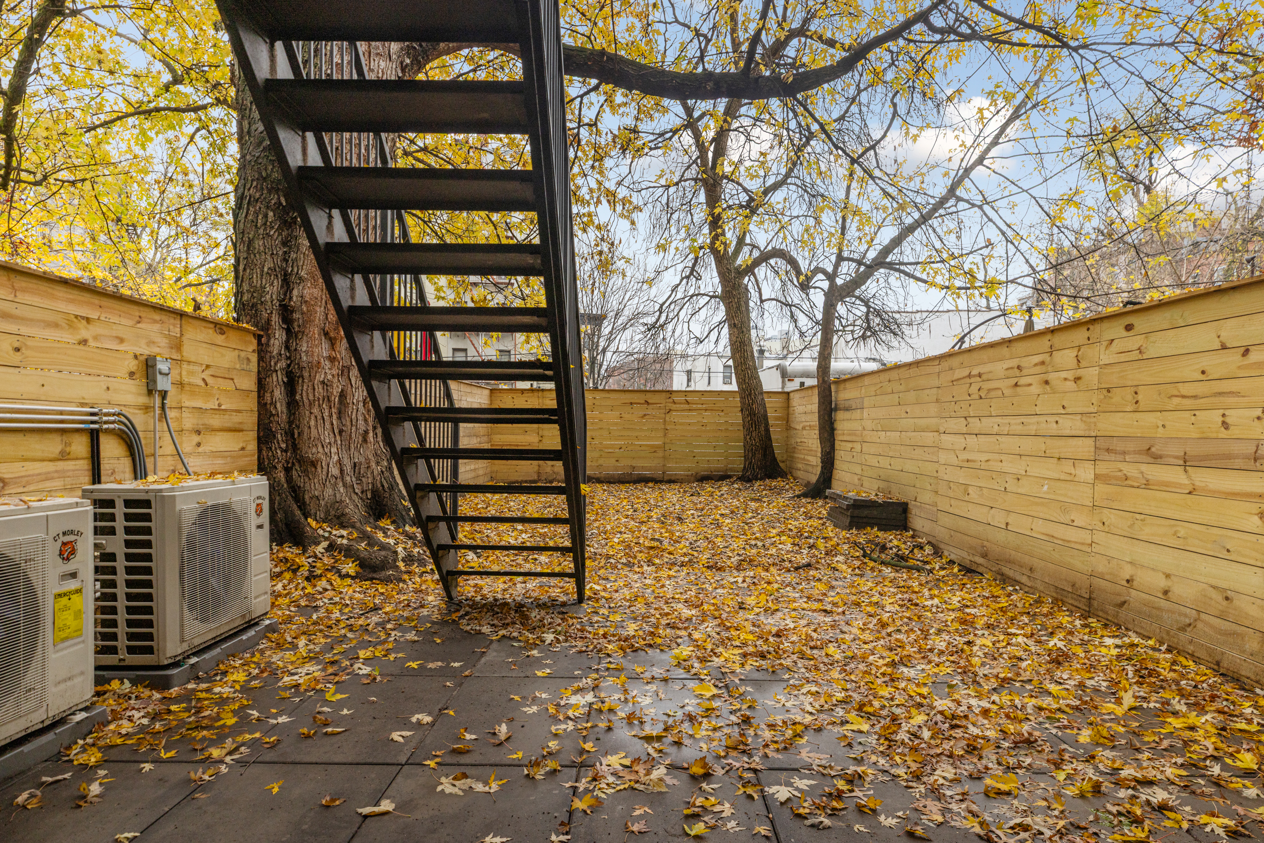 15 Verona Place, Unit GARDEN Brooklyn, NY 11216 - Photo 13 of 14 a backyard of a house with wooden fence and trees