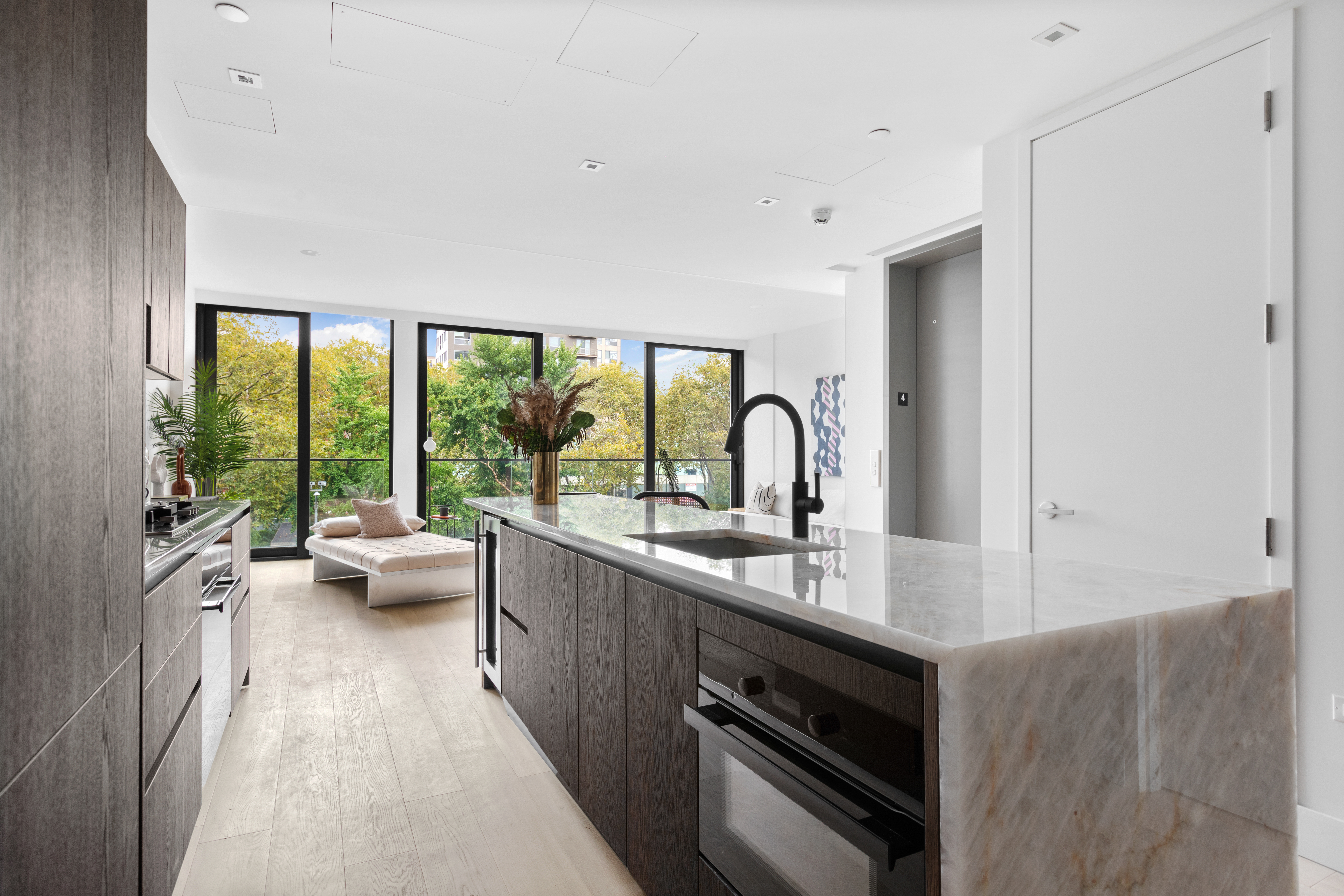 165 Chrystie Street, Unit 3 Manhattan, NY 10002 - Photo 2 of 13 a kitchen with sink a large window and view of living room