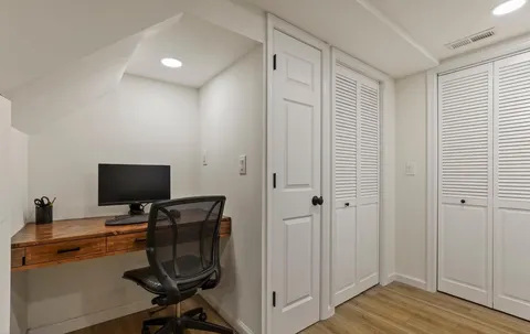 a view of workspace with wooden floor windows