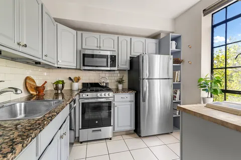 a kitchen with a refrigerator sink and cabinets